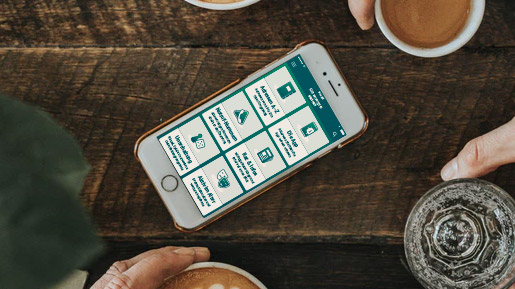 Liegendes Handy, zwischen Menschen die Kaffee trinken.
